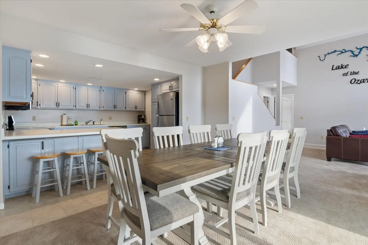 This image features a spacious interior with a dining table, kitchen island, and decorative wall art. The setting is well-lit, comfortable, and inviting, embodying both productivity and relaxation in a shared living space.