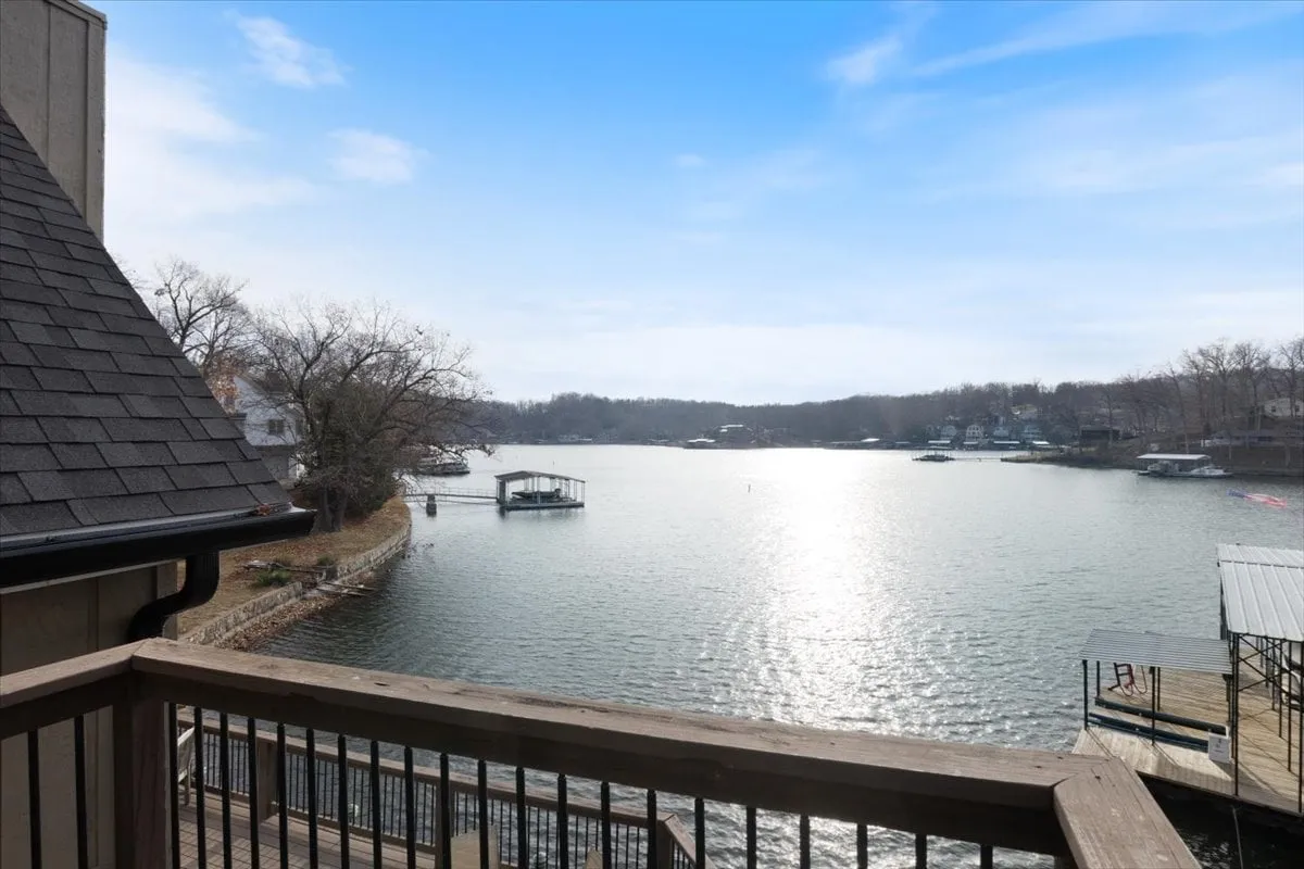 A panoramic view of the lake with a dock, trees, and nearby houses. The scene shows peaceful water ideal for boating or fishing, with plenty of open space for picnics or lakeside relaxation. The inviting environment reflects the neighborhood's family-friendly appeal and opportunities for exploration.